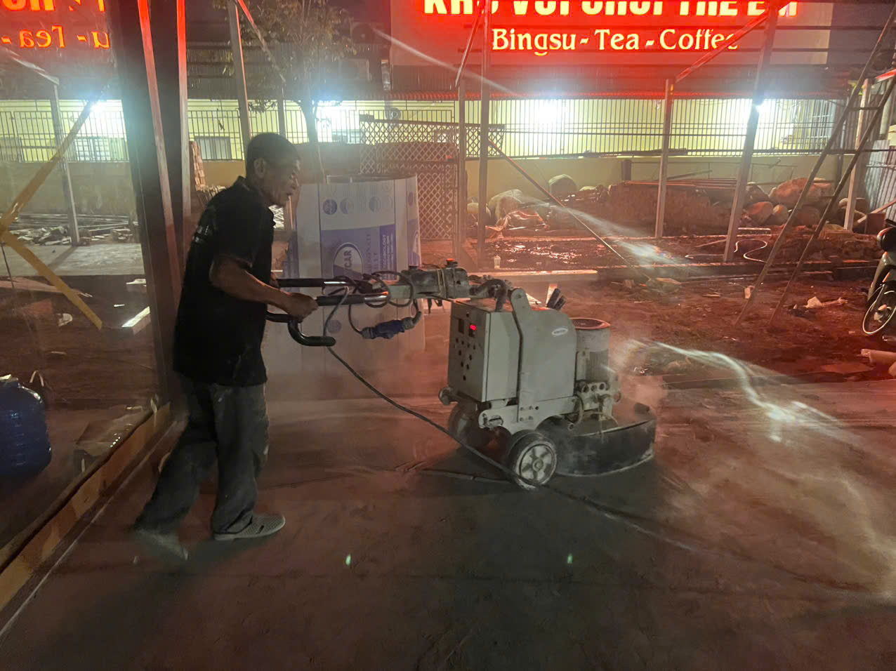 thợ vận hành máy mài để xử lý bề mặt sàn bê tông thực tế