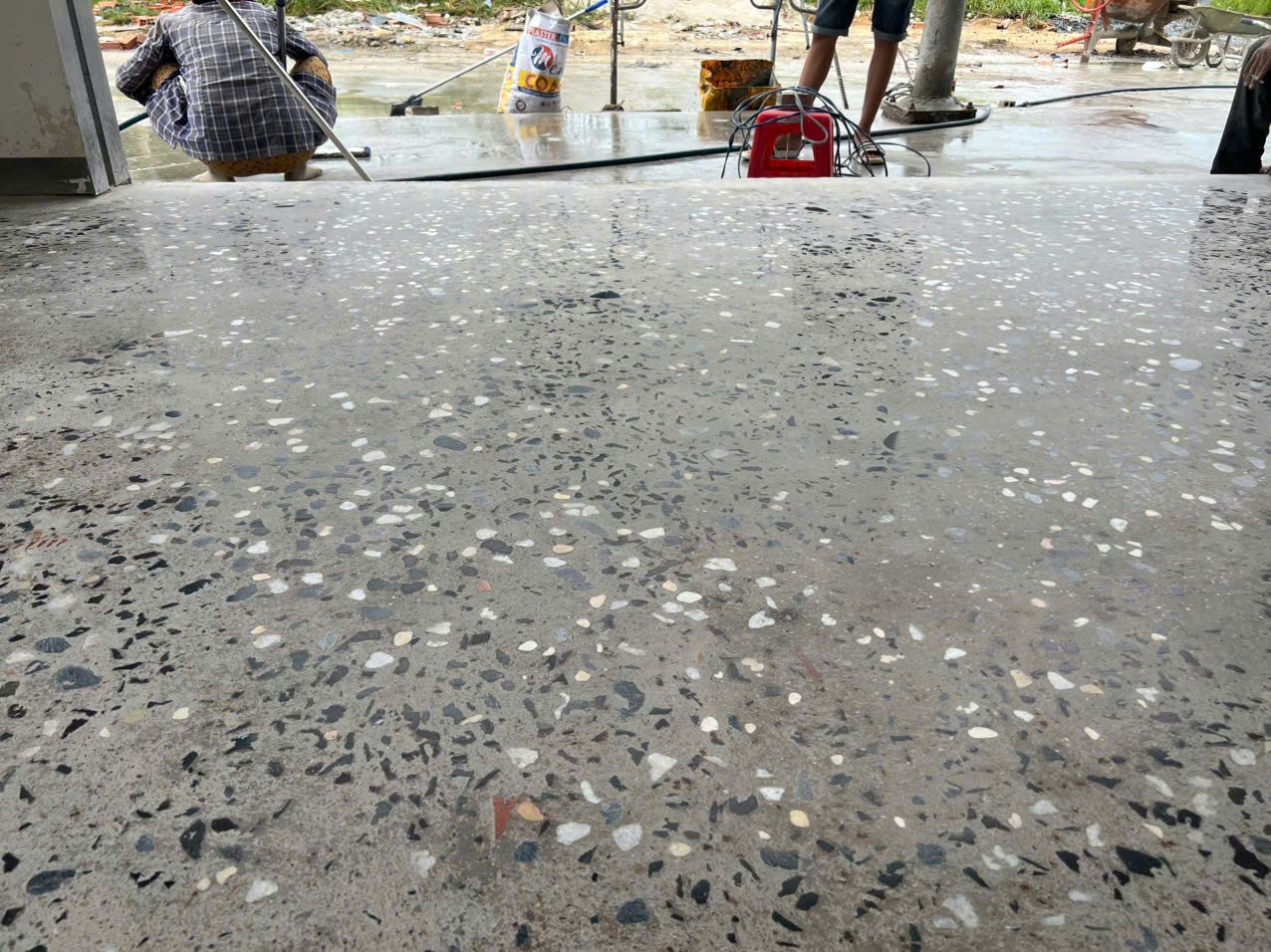 Bề mặt bê tông lộ cốt liệu trong quá trình xử lý thực tế Bề mặt bê tông lộ cốt liệu đang được xử lý tại công trình thực tế