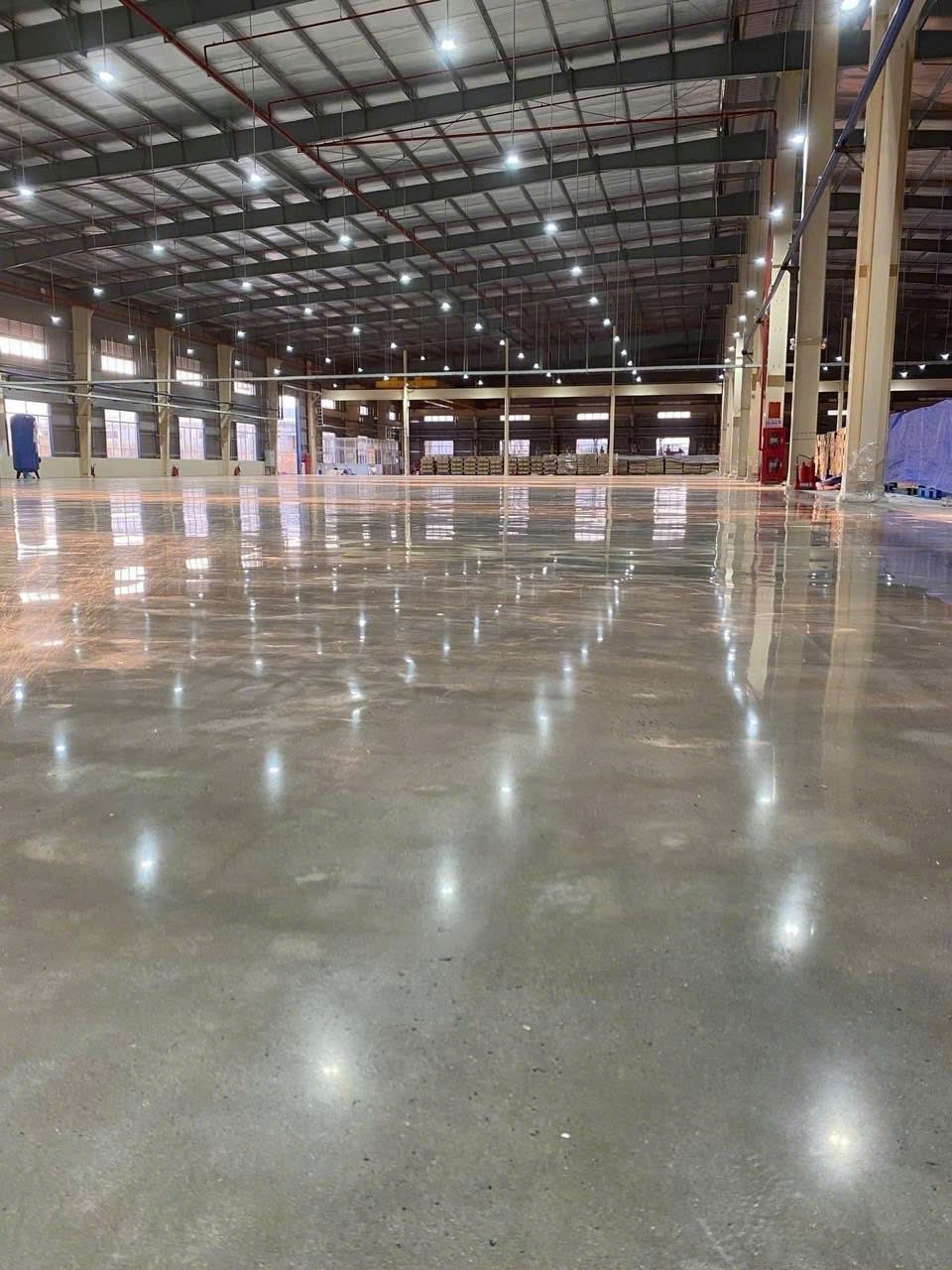 Bề mặt bê tông đánh bóng phản sáng trong ảnh thực tế Bề mặt sàn bê tông đánh bóng phản sáng tại công trình thực tế